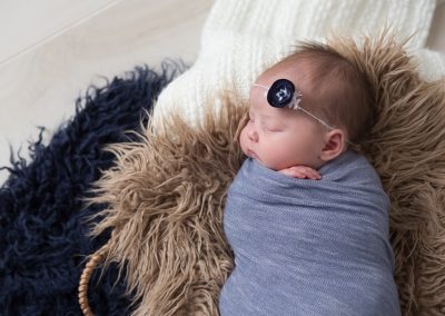 Newborn baby girl in blue, navy, cream, and tan. Photo by Colleen Hight Photography.