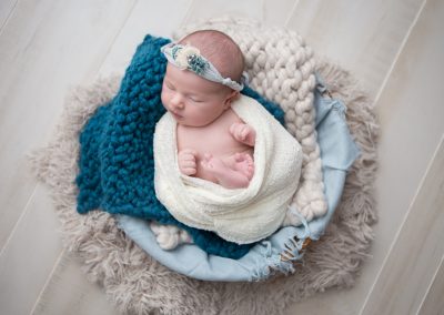 Newborn baby girl with cream and teal color pallet in Suwanee Georgia Studio